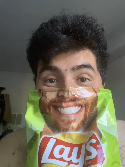 Rico holding a bag of chips over his face