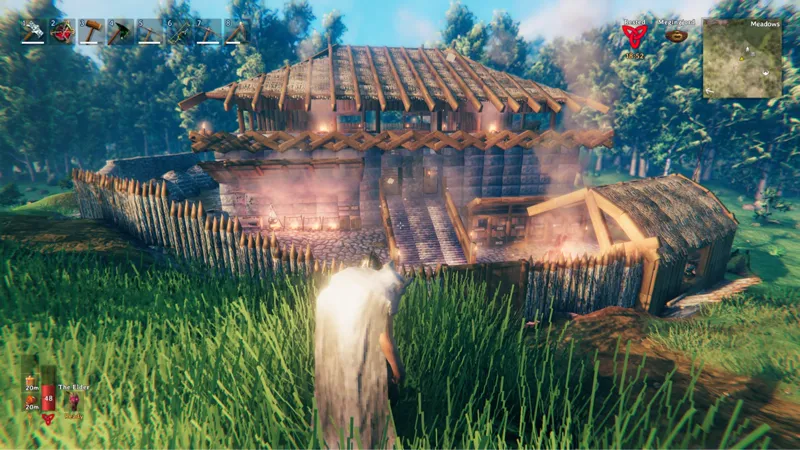 Our Valheim longhouse with stone walls and a wooden palisade