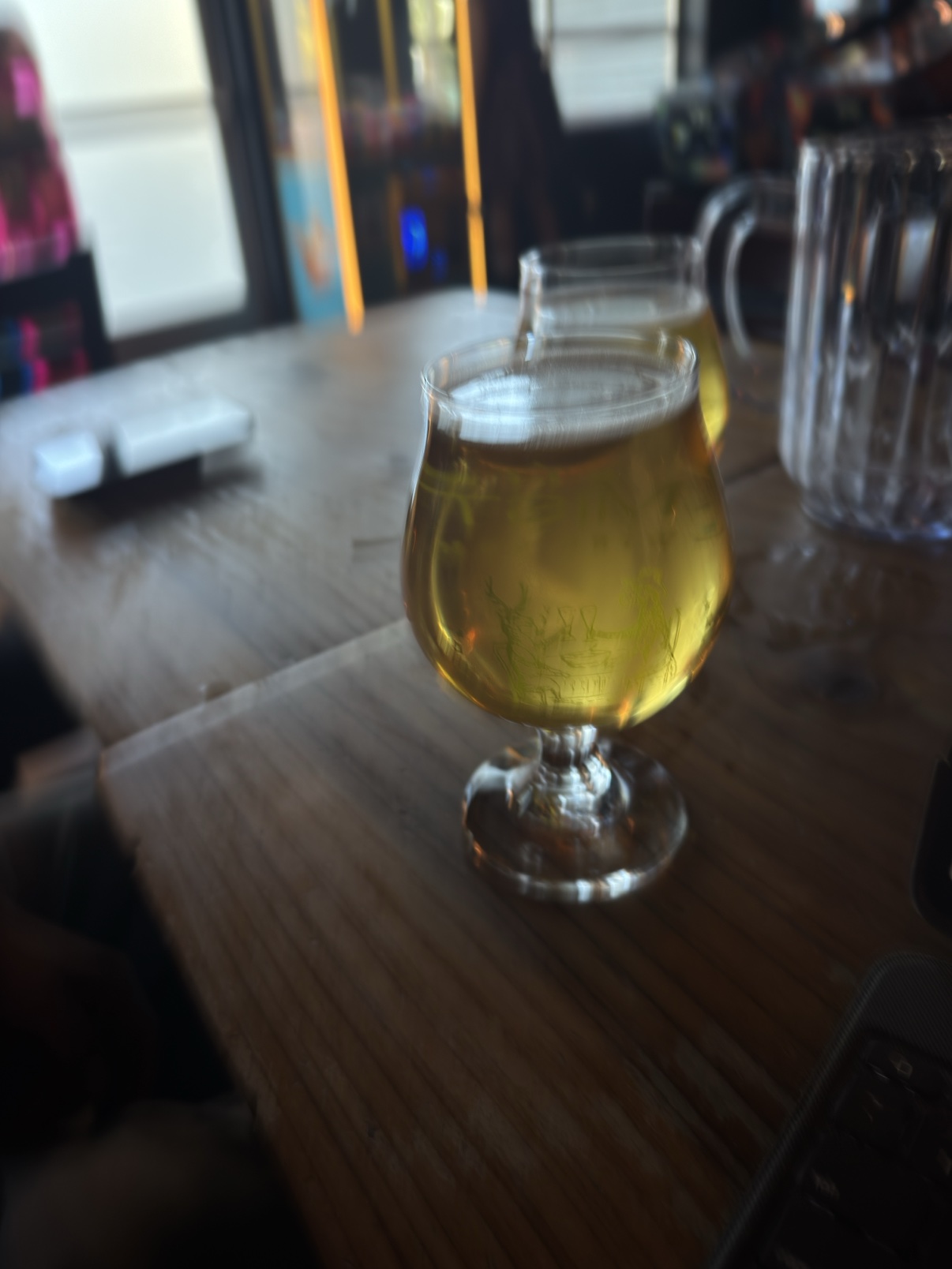 A glass of NA beer on the wooden table at the brewery
